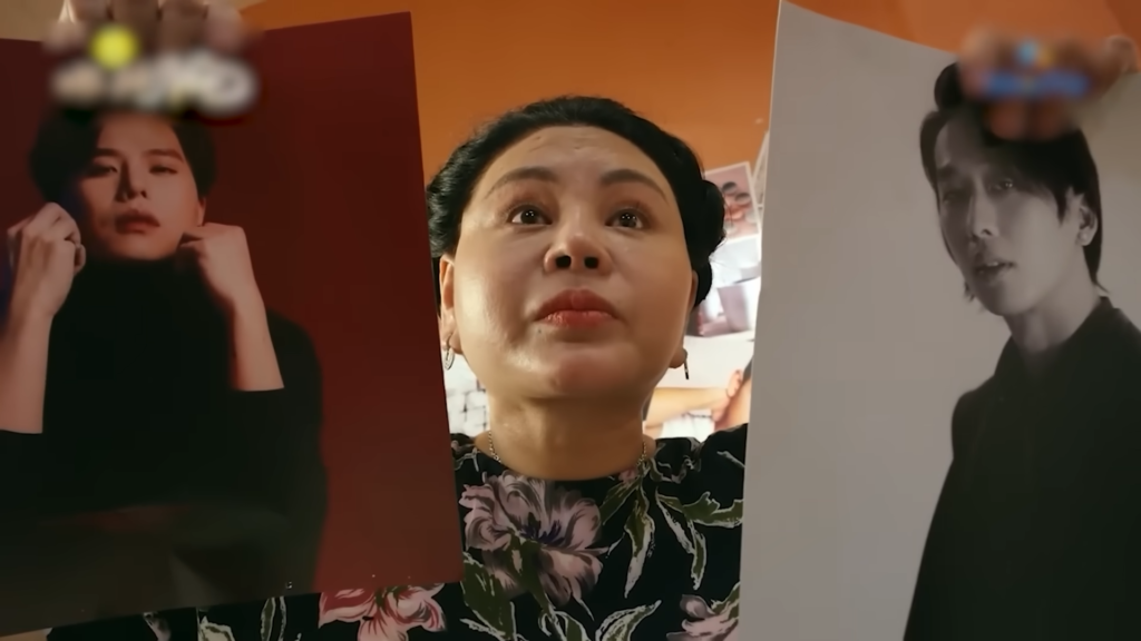 Trong Nhà Bà Nữ, ngay từ những phút đầu, bà Nữ cầm hai tấm poster đàn ông lên và hỏi tại sao con gái Nhi lại để ảnh đàn ông trong phòng.