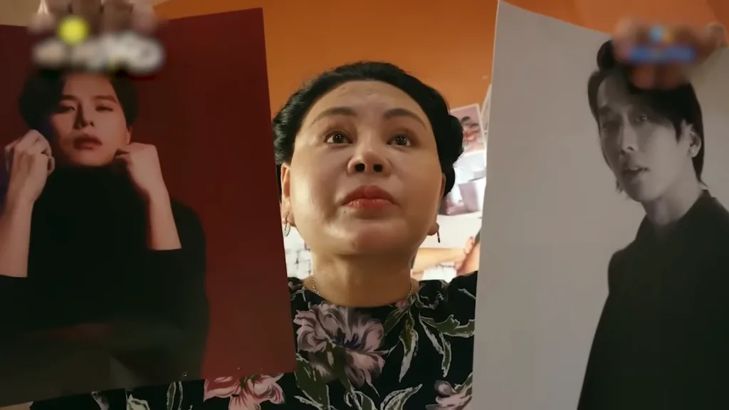 Trong Nhà Bà Nữ, ngay từ những phút đầu, bà Nữ cầm hai tấm poster đàn ông lên và hỏi tại sao con gái Nhi lại để ảnh đàn ông trong phòng.